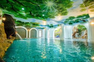 a swimming pool with a waterfall in the middle at HELLO VILLA & SPA in Hue