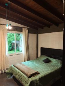 a bedroom with a green bed and a window at Nuevos Aires in Mar de las Pampas