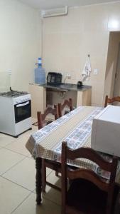 a kitchen with a stove and a table with chairs at Apê perto do Parque Euclides Dourado in Garanhuns +9 photos