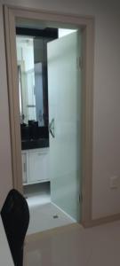 Habitación con vistas a un baño con espejo y puerta. en Pousada Lima, en Volta Redonda