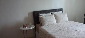 Un dormitorio con una cama y una mesita de noche. en Pousada Lima, en Volta Redonda