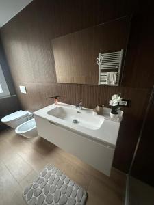 a bathroom with a white sink and a toilet at Casa Orchidea in Genova