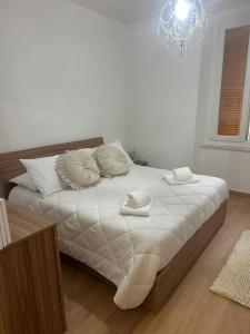 a bedroom with a large bed with white sheets and pillows at Casa Orchidea in Genova