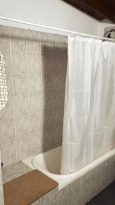 a bathroom with a bath tub with a shower curtain at Nuevos Aires in Mar de las Pampas