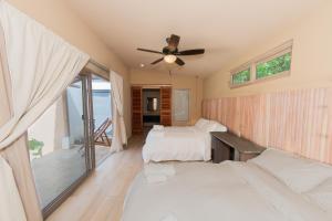 a bedroom with two beds and a ceiling fan at Casa Nära Hotel in El Sucio