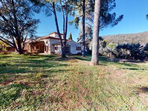 une maison avec des arbres devant une cour dans l'établissement Villa familiale 7 pièces avec jardin et piscine à Agones - FR-1-785-29, à Ganges