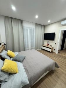 a bedroom with a large bed with yellow pillows at Danubia-residence in Komárno