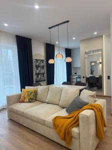 a living room with a white couch with a blanket at Danubia-residence in Komárno