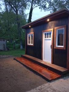 ein kleines Haus mit einer Veranda und einer weißen Tür in der Unterkunft El monito de Sanber in San Bernardo