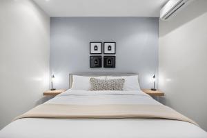 a white bedroom with a large bed with two lamps at Casa Placita Hotel in San Juan