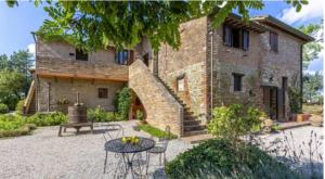 ein großes Backsteinhaus mit einem Tisch davor in der Unterkunft Agritur Villa Osvaldo Castiglione del Lago Perugia Piscina acqua salata possibilità colazione in Castiglione del Lago