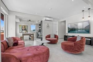a living room with two red chairs and a table at Casa Placita Hotel in San Juan