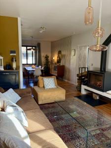 un salon avec un canapé et une table en verre dans l'établissement Venez Chez Vous Parenthese du lac, à Lathuile