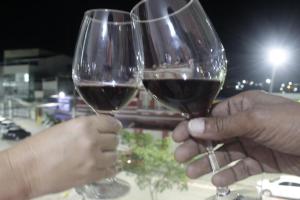 two people holding up glasses of red wine at Canto do Florescer in Pesqueira