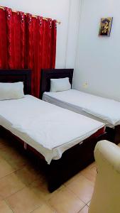 2 camas en una habitación con cortinas rojas en Hotel Al safa, en Hyderabad