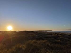 ein Sonnenuntergang über einem Feld mit der Sonne im Hintergrund in der Unterkunft 10 person holiday home in Brovst-By Traum in Brovst