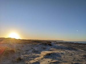 einen Sonnenuntergang am Strand mit Sonne im Hintergrund in der Unterkunft 10 person holiday home in Brovst-By Traum in Brovst