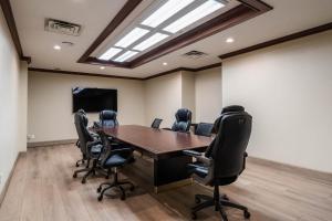 Una sala de conferencias con una mesa de madera y sillas negras. en Ramada Plaza by Wyndham Niagara Falls, en Niagara Falls 42 fotos más