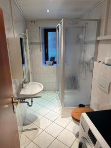 une salle de bain blanche avec lavabo et douche dans l'établissement Ferienwohnung Stiegel, à Ingelheim-sur-le-Rhin