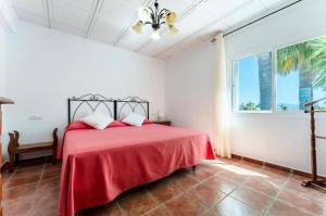 una camera con letto rosso in una stanza con finestra di Villa Paula-Los Manantiales ad Alhaurín de la Torre Altre 25 foto