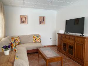 un soggiorno con divano e TV a schermo piatto di Villa Paula-Los Manantiales ad Alhaurín de la Torre