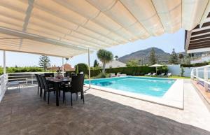 un patio con tavolo e sedie e una piscina di Villa Paula-Los Manantiales ad Alhaurín de la Torre