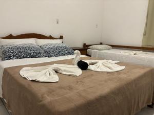 two beds with towels on them in a bedroom at Pousada Casarão - Pé na Areia Cumuruxatiba in Cumuruxatiba +16 photos