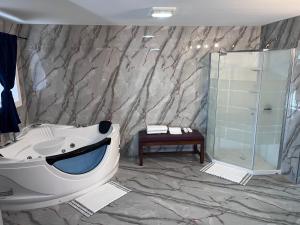 uma casa de banho com uma banheira grande e um chuveiro em Chaplin Inn & Suites em Chaplin