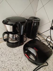 a coffee maker on a counter next to a coffee pot at Paraiso 162E in Santa Maria