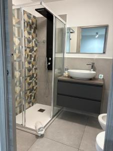 a bathroom with a glass shower and a sink at Cortili Himeresi in Termini Imerese +10 photos