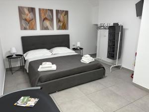 a bedroom with a large bed with two towels on it at Cortili Himeresi in Termini Imerese