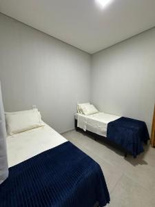 una camera da letto con due letti in una stanza di Hotel União Centro a Inocência