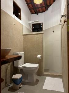 a bathroom with a toilet and a sink and a shower at Pousada Casarão - Pé na Areia Cumuruxatiba in Cumuruxatiba