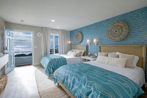 two beds in a hotel room with blue walls at Black Sands Inn in Whitethorn