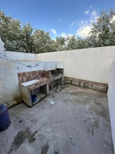 una panchina di cemento appoggiata a un muro di Duplex Las Malvinas a Las Toninas