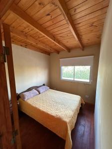 una camera da letto con un letto in una stanza con una finestra di Duplex Las Malvinas a Las Toninas