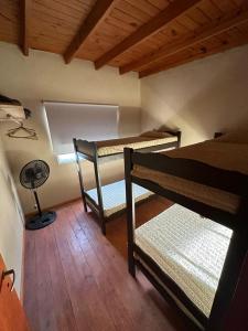 Camera con 3 letti a castello e un ventilatore. di Duplex Las Malvinas a Las Toninas