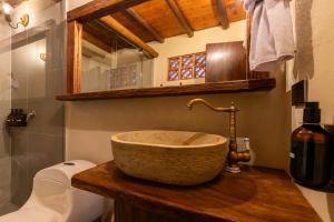 baño con lavabo de piedra en una encimera de madera en Unique, en Guatapé 72 fotos más