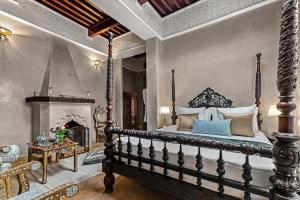 Un dormitorio con una cama y una chimenea. en Riad ILayka, en Marrakech