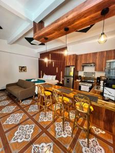 eine Küche und ein Wohnzimmer mit einem Sofa und Stühlen in der Unterkunft Loft Lujoso y Moderno in Puerto Barrios
