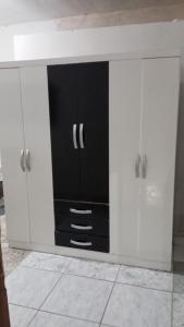 a white cabinet with black doors in a kitchen at Hotel 5 irmãos in Araripina