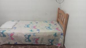 a small bed in a corner of a room at Hotel 5 irmãos in Araripina