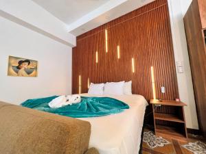 ein Schlafzimmer mit einem Bett mit einer grünen Decke darauf in der Unterkunft Loft Lujoso y Moderno in Puerto Barrios