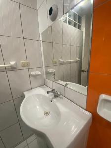 a bathroom with a white sink and a mirror at La casa de Betty in Huancayo