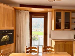 een keuken met een tafel en een raam met uitzicht bij Ca' Prestin - Natura e Relax a 20 minuti da Bormio in Tovo di Sant'Agata