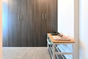 a table with a pair of shoes on it next to a closet at SOP06 Stylish and Cosy 2 Bedroom Apt in Sydney +24 photos