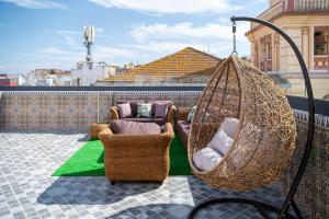 a porch with two chairs and a hammock on a balcony at Dar Belleza in Tangier