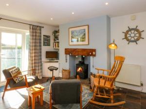 a living room with a fireplace and a couch at Curragho in Trearddur