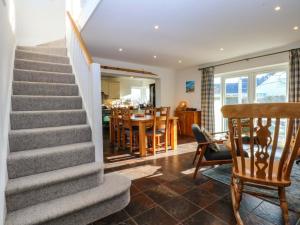 a staircase in a home with a dining room and kitchen at Curragho in Trearddur