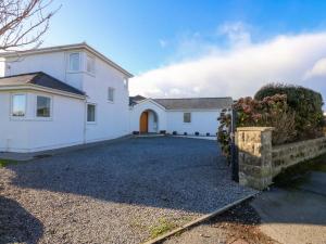 a large white house with a driveway at Curragho in Trearddur